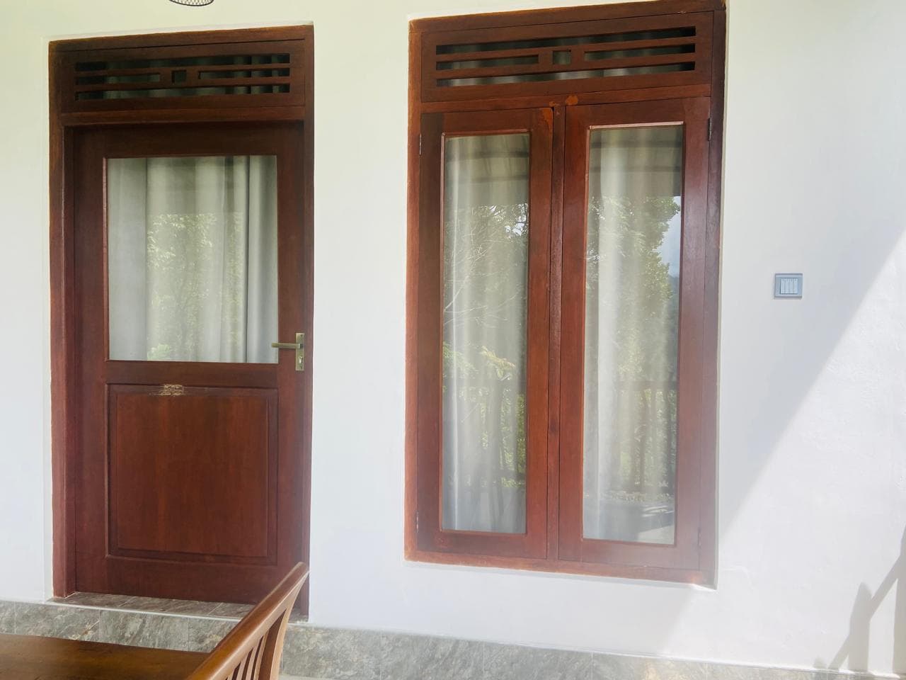 Wooden balcony door and windows of the Hidden Cove room