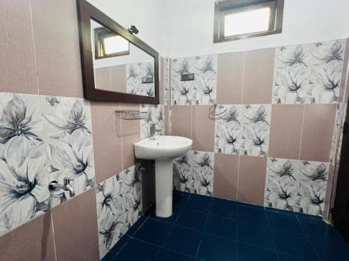 Hidden Cove bathroom with floral tiles, basin and high window