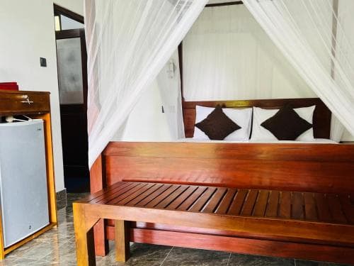 Wooden bench and mini fridge beside the Hidden Cove bed